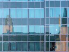 Odbicie wieży Starego Browaru w oknach biurowca