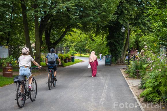 Kobieta spacerującą po Cytadeli i rowerzyści