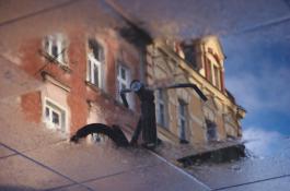 Odbicie w kałuży - Kamienica na Śródce wraz ze starym rowerem