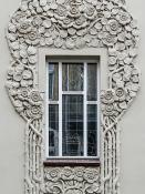 Secesyjne okno z dekoracją roślinną na fasadzie kamienicy w Poznaniu